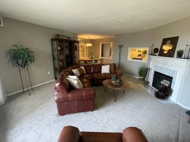 carpeted living room with a textured ceiling, visible vents, a fireplace, an inviting chandelier, and baseboards