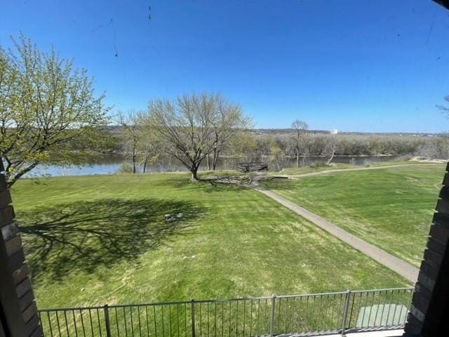 view of home's community with a yard, fence, and a water view