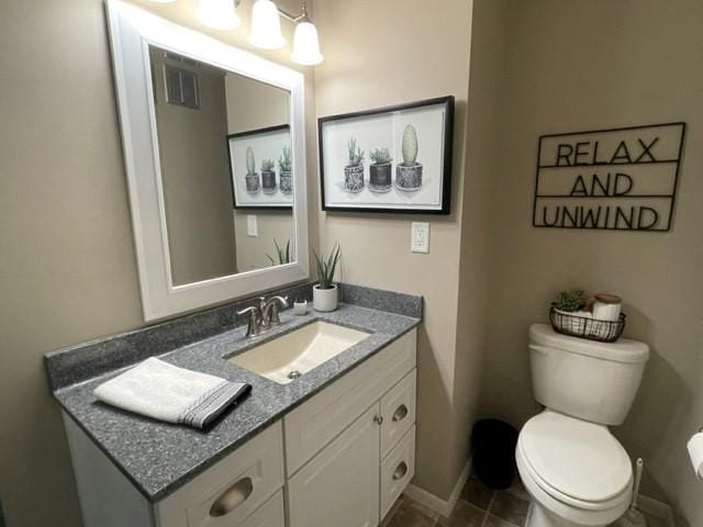 bathroom featuring toilet, baseboards, vanity, and visible vents