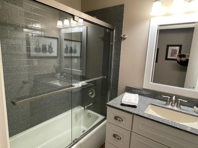 full bath with enclosed tub / shower combo and vanity