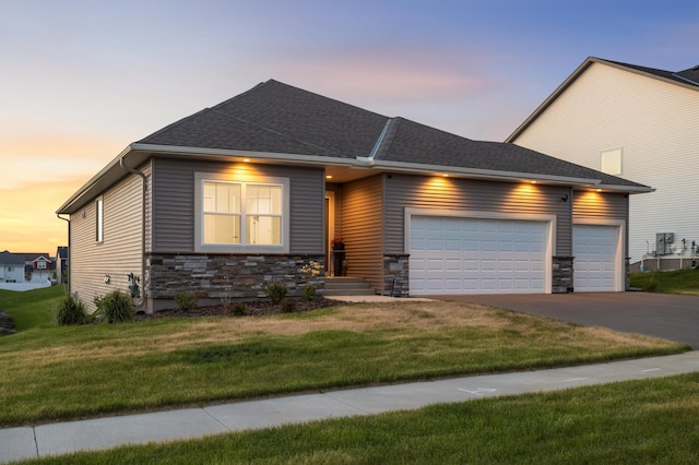 7107 184th St W, Lakeville, MN 55044 - view of front of property with an attached garage, stone siding, driveway, and a yard
