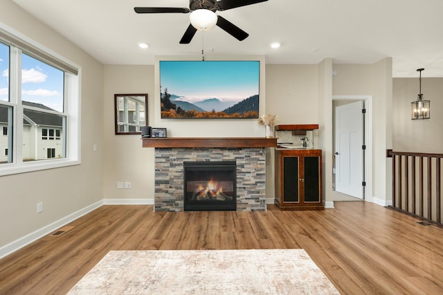 7107 184th St W, Lakeville, MN 55044 - unfurnished living room with wood finished floors, a ceiling fan, baseboards, a fireplace, and recessed lighting
