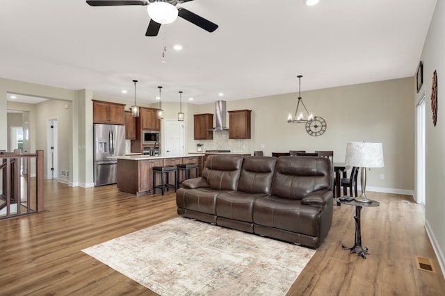 7107 184th St W, Lakeville, MN 55044 - living room featuring wood finished floors, ceiling fan, baseboards, a chandelier, and recessed lighting