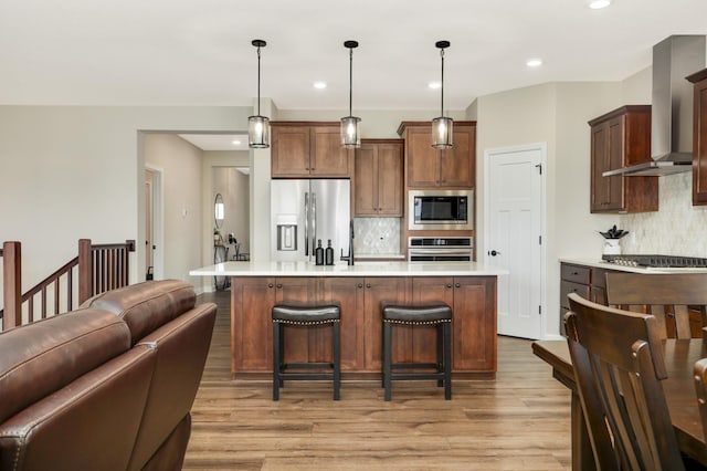 7107 184th St W, Lakeville, MN 55044 - kitchen with appliances with stainless steel finishes, wall chimney exhaust hood, open floor plan, decorative backsplash, and recessed lighting