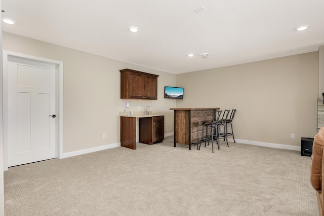 7107 184th St W, Lakeville, MN 55044 - kitchen featuring light colored carpet, a kitchen bar, baseboards, and recessed lighting
