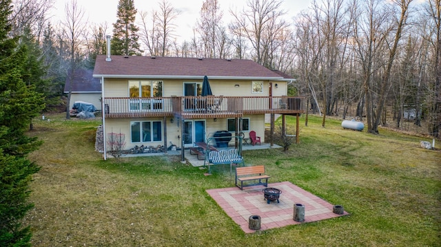 back of house featuring an outdoor fire pit, a patio area, a yard, and a deck