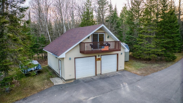 detached garage featuring a view of trees