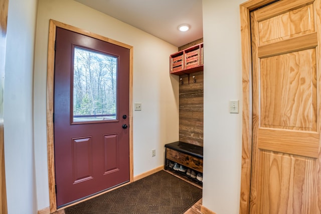 mudroom with dark colored carpet and baseboards