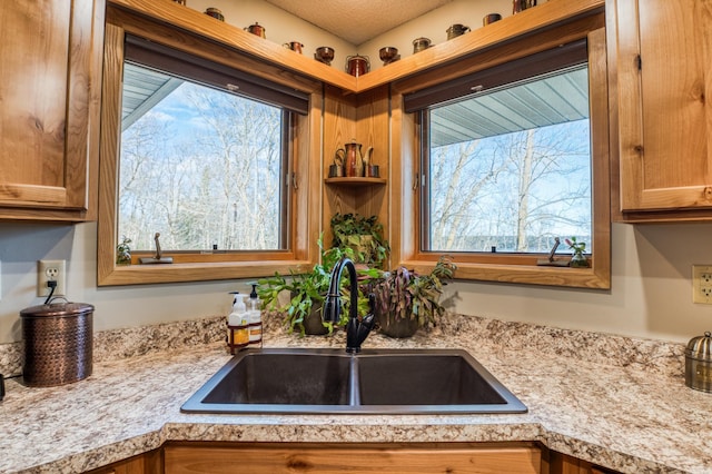 kitchen with a sink, light countertops, and brown cabinets