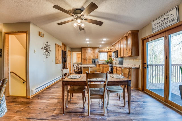 dining room with a baseboard radiator, baseboards, ceiling fan, and wood finished floors
