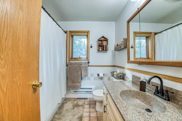 bathroom featuring tile patterned flooring, a textured ceiling, plenty of natural light, and a baseboard heating unit