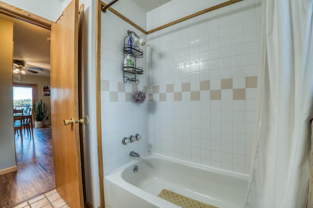 full bath with a ceiling fan, a textured ceiling, baseboards, tile patterned floors, and shower / bathtub combination with curtain