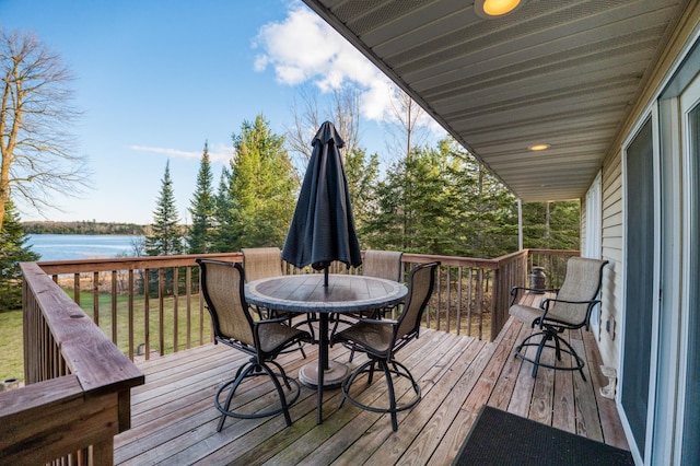 wooden terrace featuring a water view and outdoor dining area