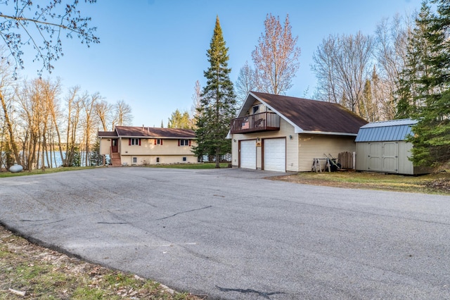 view of home's exterior featuring an outdoor structure, a garage, and a storage unit
