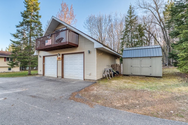 view of side of property with a balcony, an outdoor structure, and a storage shed