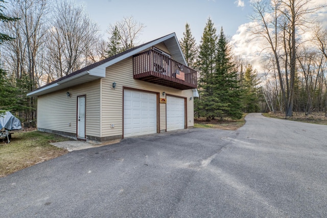 view of side of property with an outdoor structure, a wooden deck, and a detached garage