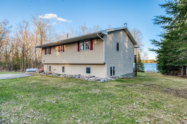 view of side of home with a yard