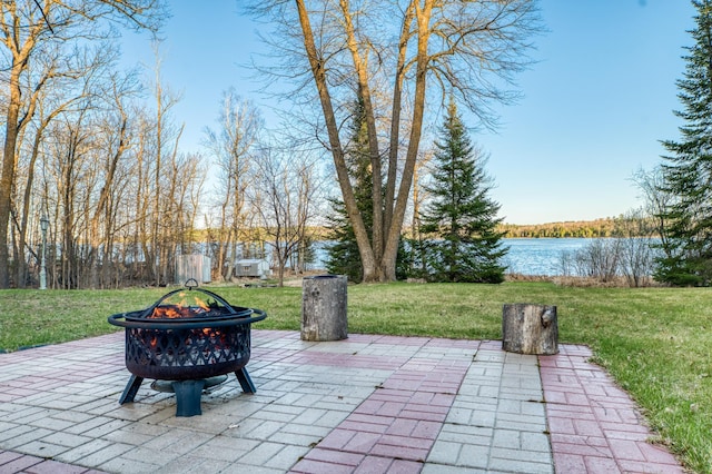view of patio with a water view and a fire pit