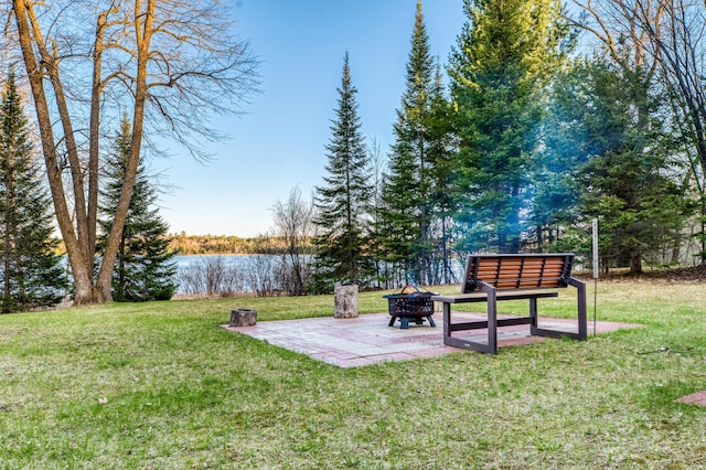 view of yard with an outdoor fire pit, a water view, and a patio