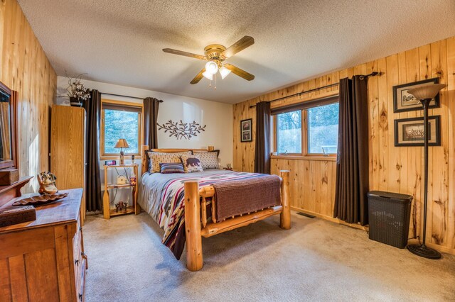 32061 Primrose Ln, Walker, MN 56461 - bedroom with wood walls, light carpet, a textured ceiling, and a ceiling fan
