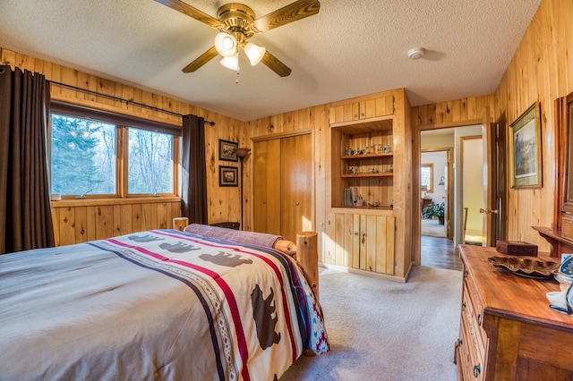32061 Primrose Ln, Walker, MN 56461 - carpeted bedroom with wood walls, a textured ceiling, and ceiling fan
