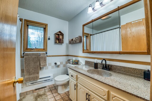 32061 Primrose Ln, Walker, MN 56461 - bathroom with toilet, vanity, tile patterned floors, tile walls, and wainscoting