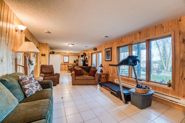 32061 Primrose Ln, Walker, MN 56461 - living room featuring wooden walls, a textured ceiling, light tile patterned flooring, and a baseboard radiator