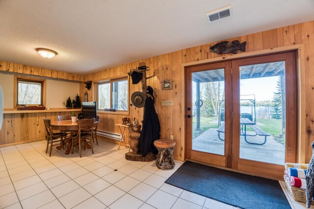 32061 Primrose Ln, Walker, MN 56461 - dining space with wood walls, light tile patterned floors, baseboard heating, and a textured ceiling