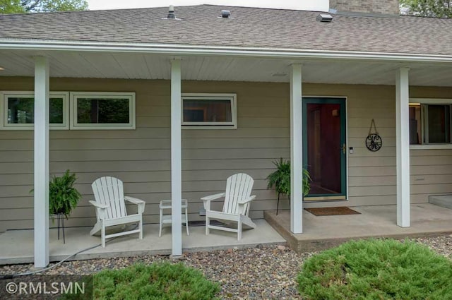 802 Flos Ct, Lincoln Twp, WI 54001 - property entrance with a shingled roof, a chimney, a patio, and a porch
