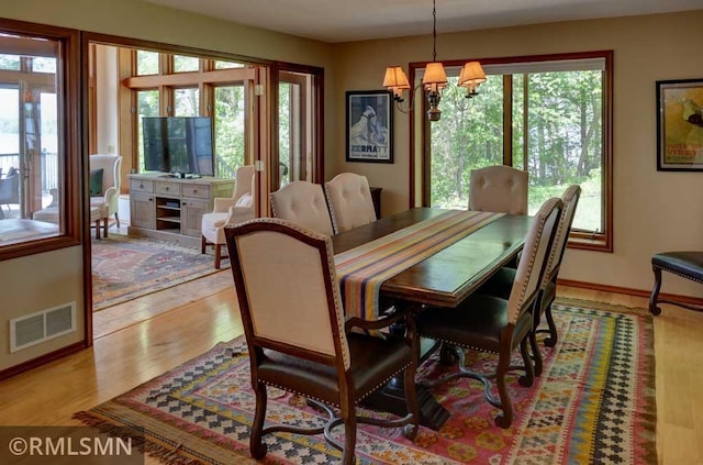 802 Flos Ct, Lincoln Twp, WI 54001 - dining area featuring a chandelier, plenty of natural light, light wood finished floors, and baseboards