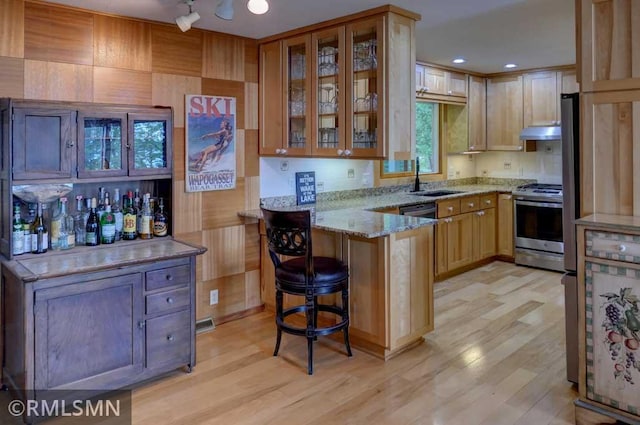 802 Flos Ct, Lincoln Twp, WI 54001 - kitchen with stainless steel range with electric cooktop, a peninsula, a sink, light wood-style flooring, and light stone counters