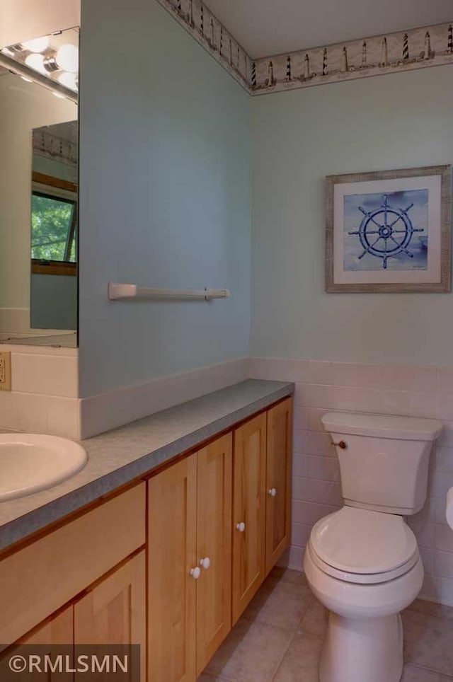 802 Flos Ct, Lincoln Twp, WI 54001 - half bath with tile patterned floors, toilet, tile walls, vanity, and a wainscoted wall