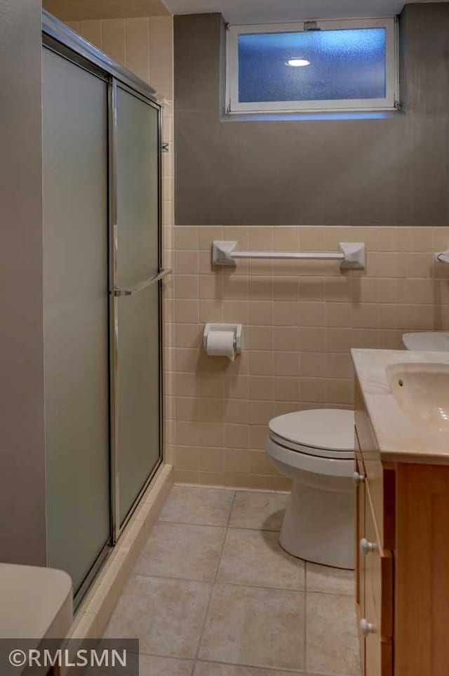 802 Flos Ct, Lincoln Twp, WI 54001 - full bathroom featuring toilet, tile walls, a stall shower, tile patterned flooring, and vanity