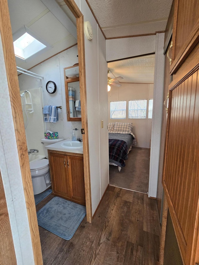 2481 Lake Miltona Dr NE Unit 1, Miltona Twp, MN 56354 - full bathroom with walk in shower, a skylight, toilet, a textured ceiling, and wood-type flooring