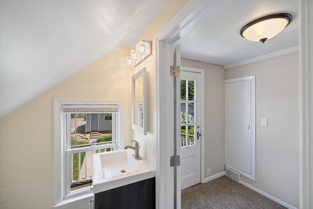 doorway with a sink, carpet floors, and baseboards