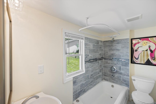 bathroom featuring bathtub / shower combination, a sink, and toilet