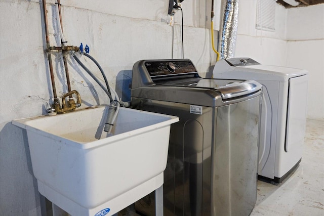 washroom with washing machine and clothes dryer and a sink