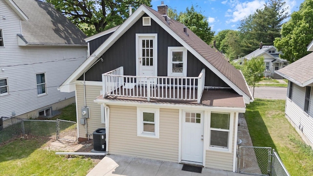 back of house with a balcony, a gate, a chimney, roof with shingles, and cooling unit