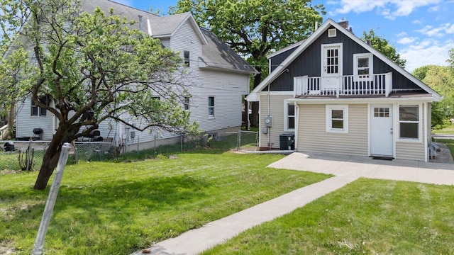rear view of property featuring board and batten siding, a chimney, a patio, and a balcony