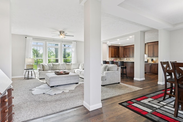 21212 Old Lake George Blvd NW, Oak Grove, MN 55303 - living room with dark wood-style floors, a ceiling fan, baseboards, ornate columns, and recessed lighting