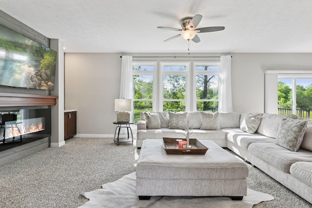 21212 Old Lake George Blvd NW, Oak Grove, MN 55303 - carpeted living room featuring a large fireplace, ceiling fan, and baseboards