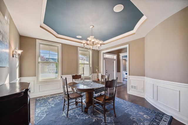 16302 Sohm Ct, Eden Prairie, MN 55347 - dining area featuring a notable chandelier, visible vents, a wainscoted wall, dark wood-type flooring, and a raised ceiling