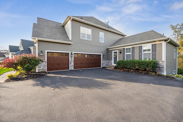 16302 Sohm Ct, Eden Prairie, MN 55347 - view of front facade with stone siding, a shingled roof, driveway, and a garage