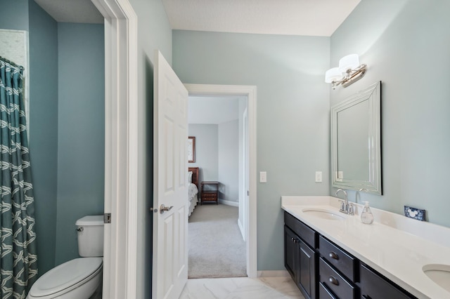16302 Sohm Ct, Eden Prairie, MN 55347 - bathroom featuring toilet, baseboards, double vanity, and a sink