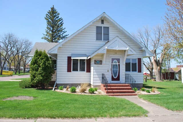 bungalow featuring a front lawn and entry steps
