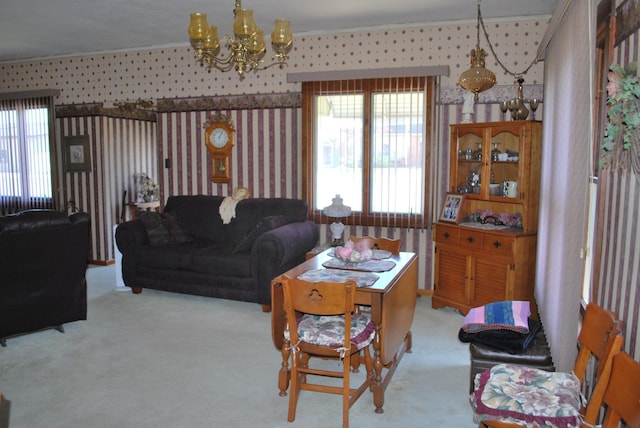 living area with a chandelier, crown molding, carpet floors, and wallpapered walls