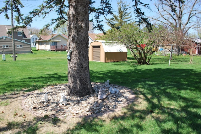 view of grassy yard with a storage shed, an outbuilding, and a residential view