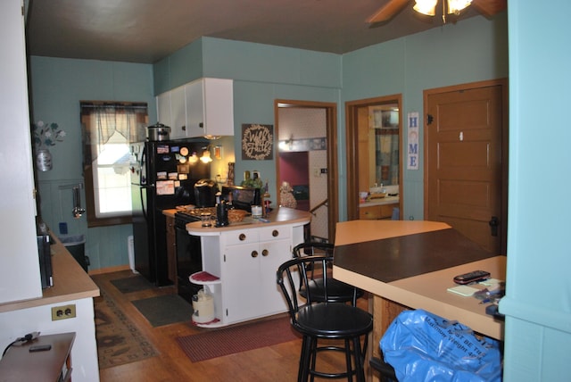kitchen with white cabinetry, dark wood-style flooring, freestanding refrigerator, and a ceiling fan