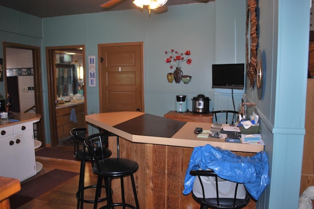 bar with a ceiling fan and wood finished floors