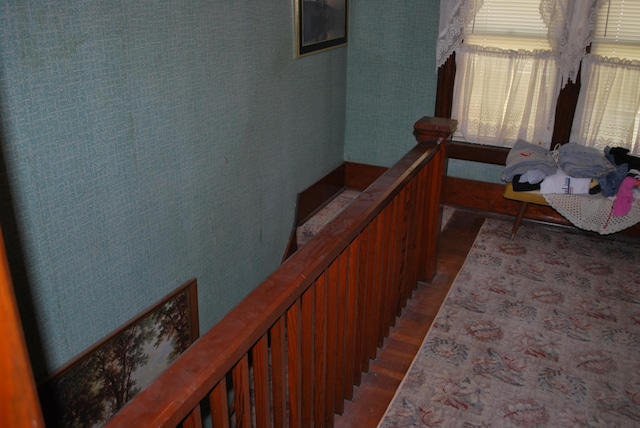 corridor featuring wood finished floors and an upstairs landing